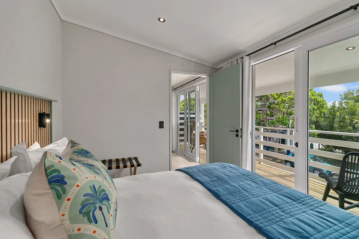 Featherbed suite bedroom with patterned throw and red accent cushion